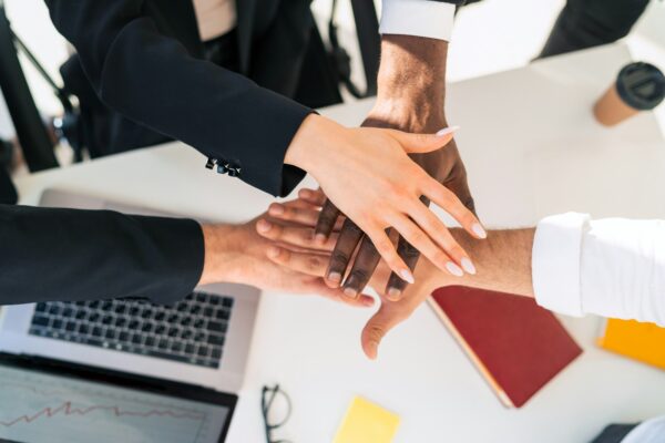 Multiracial business people staking hand together
